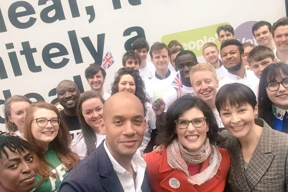 Chuka Umunna, Layla Moran, and Caroline Lucas posing together in front of young people.