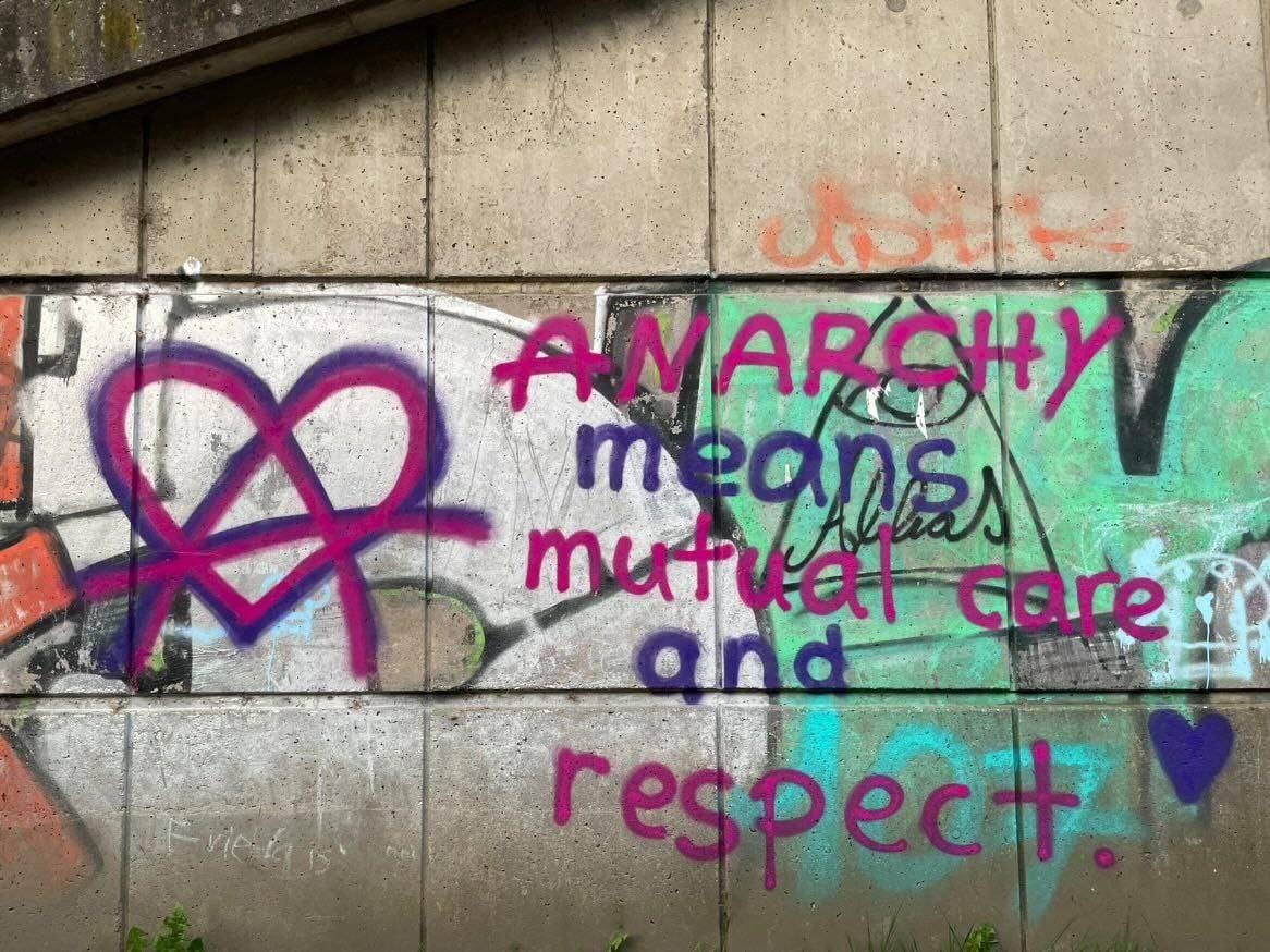 Graffiti on a wall in Wuppertal, Germany, that states "Anarchy means mutual care and respect" with an "A" inside a love heart.