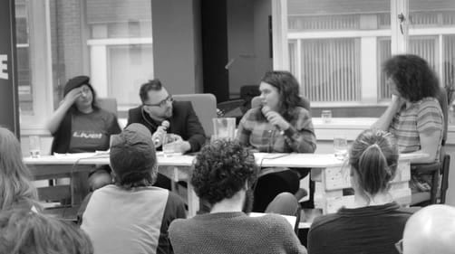Four people on a panel before an audience