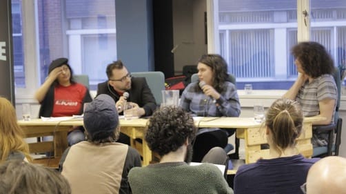 Four people on a panel before an audience