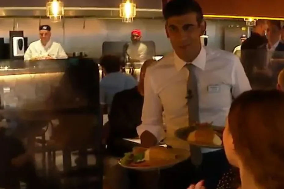 Rishi Sunak offers plates of food to people in a restaurant as a virus rages